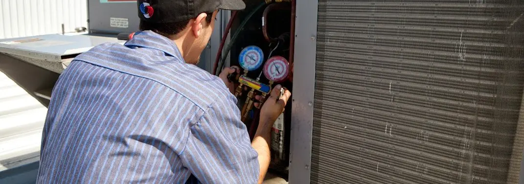 HVAC technician servicing a condenser unit in Gresham Park